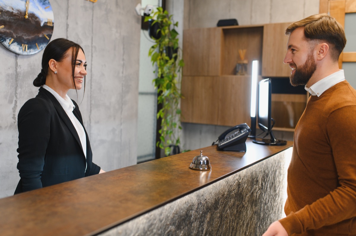 Guest speaking with a receptionist at a hotel front desk